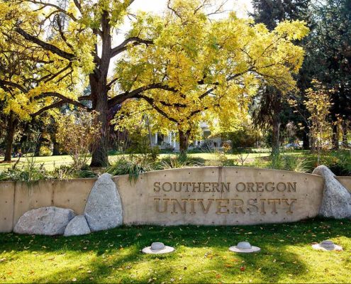 Rock sign at Southern Oregon University - Trees and grass in the background
