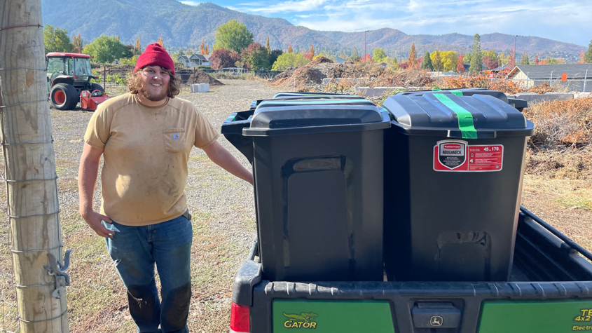 Man standing with two composting bins at SOU